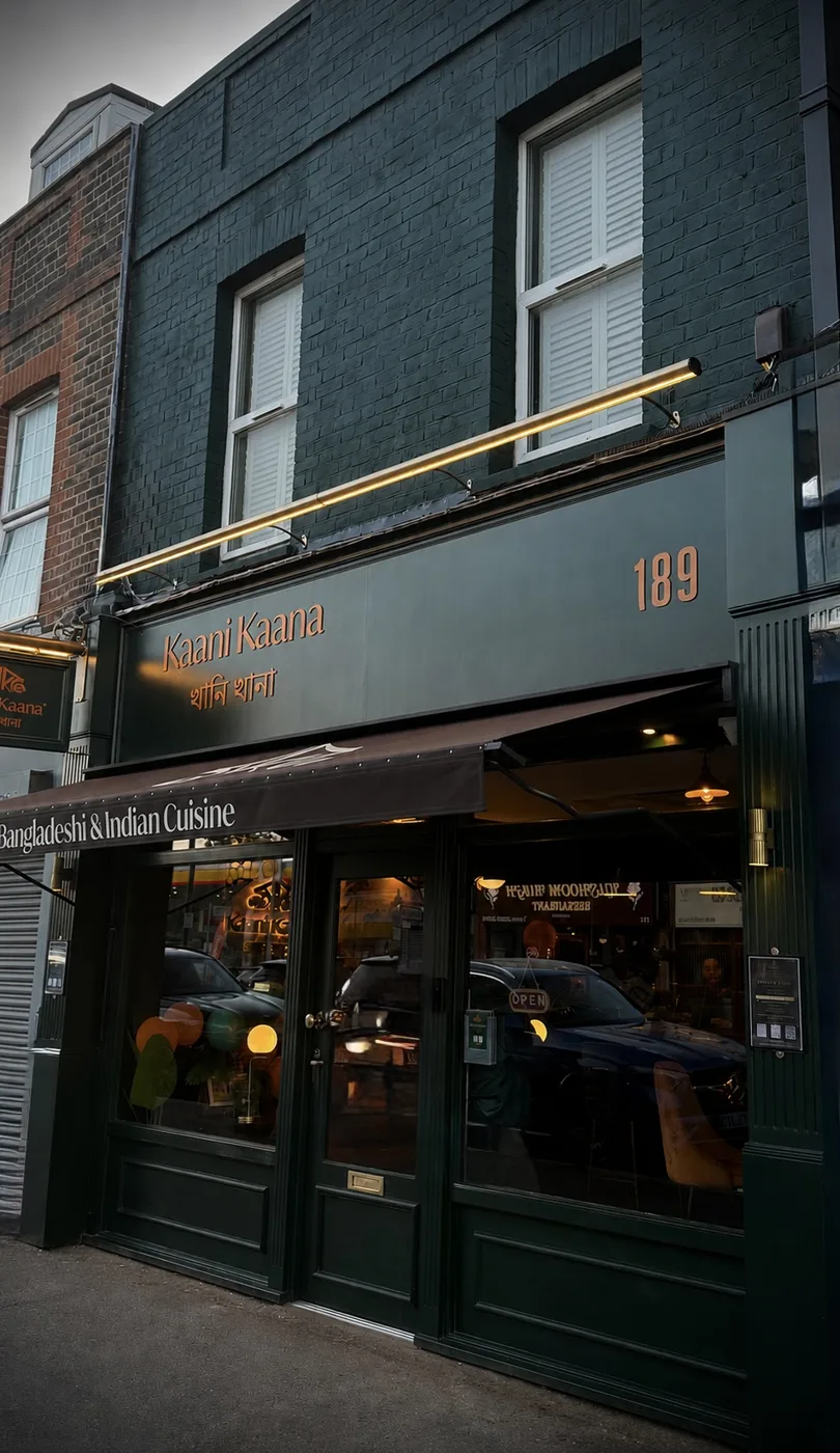 The dark green shopfront of Kaani Kaana at 189 St Mary's Lane at dusk, with a brass light bar over the sign